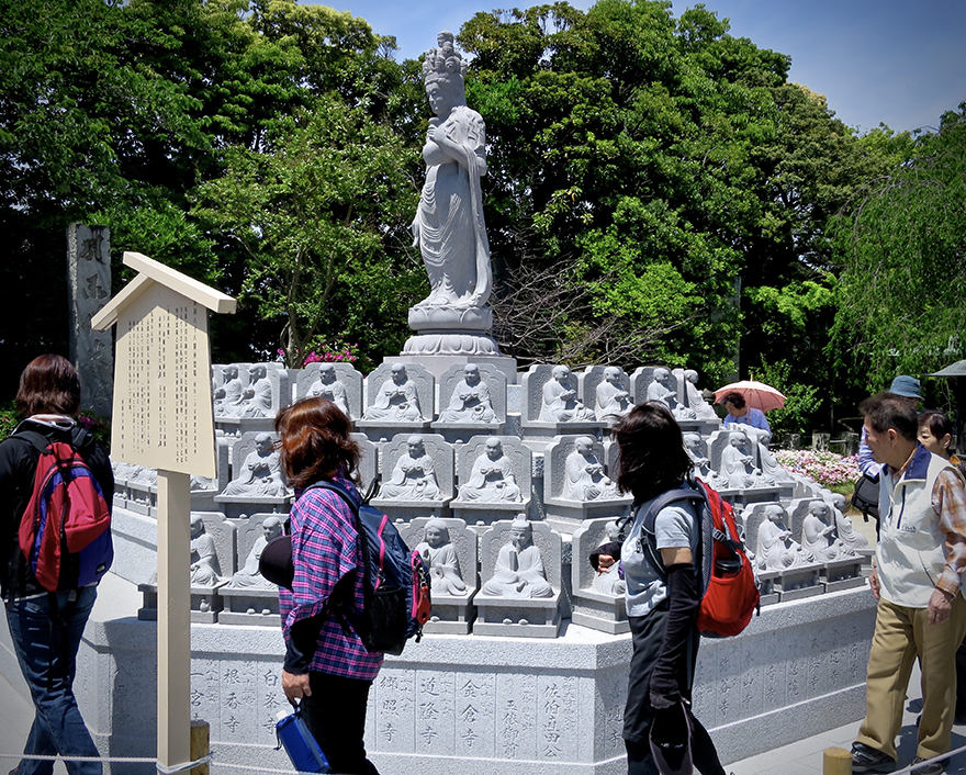 People walking around Jizo figures on pilgrimage shortcut at Nishiarai Daishi temple