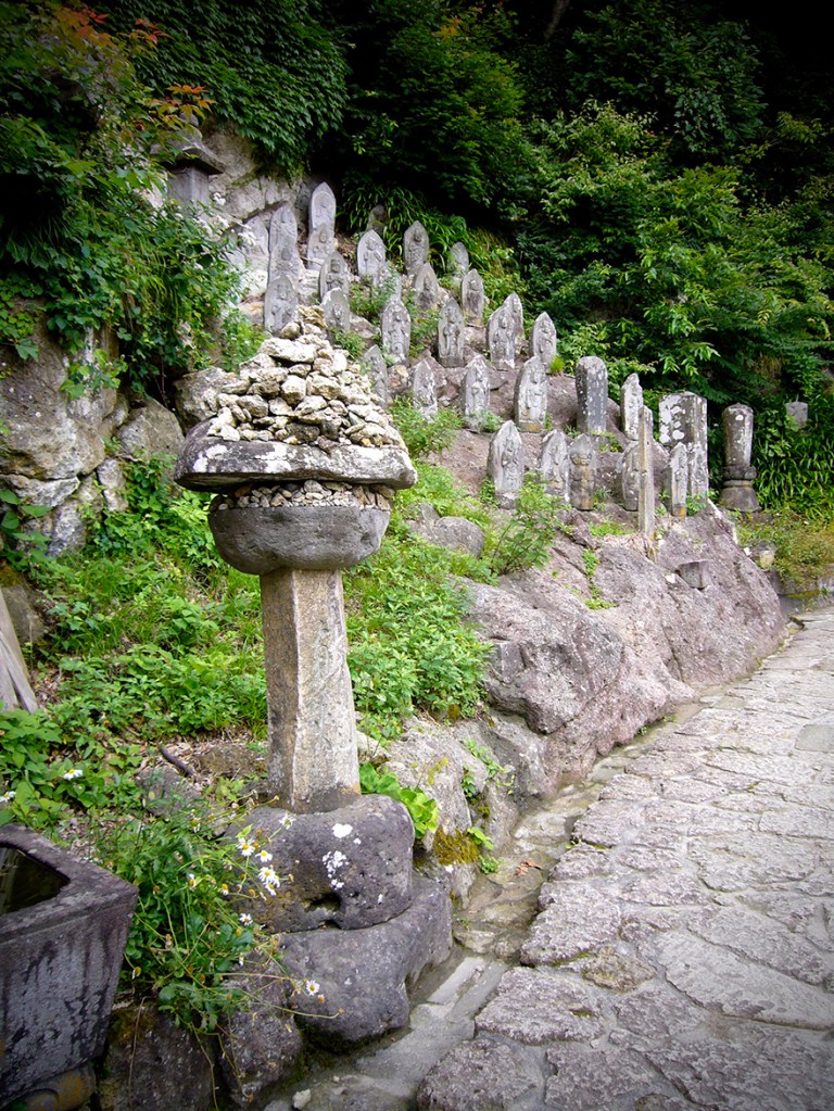 Jizo figures and stones left by pilgrims on climb to Yamadera in Yamagata