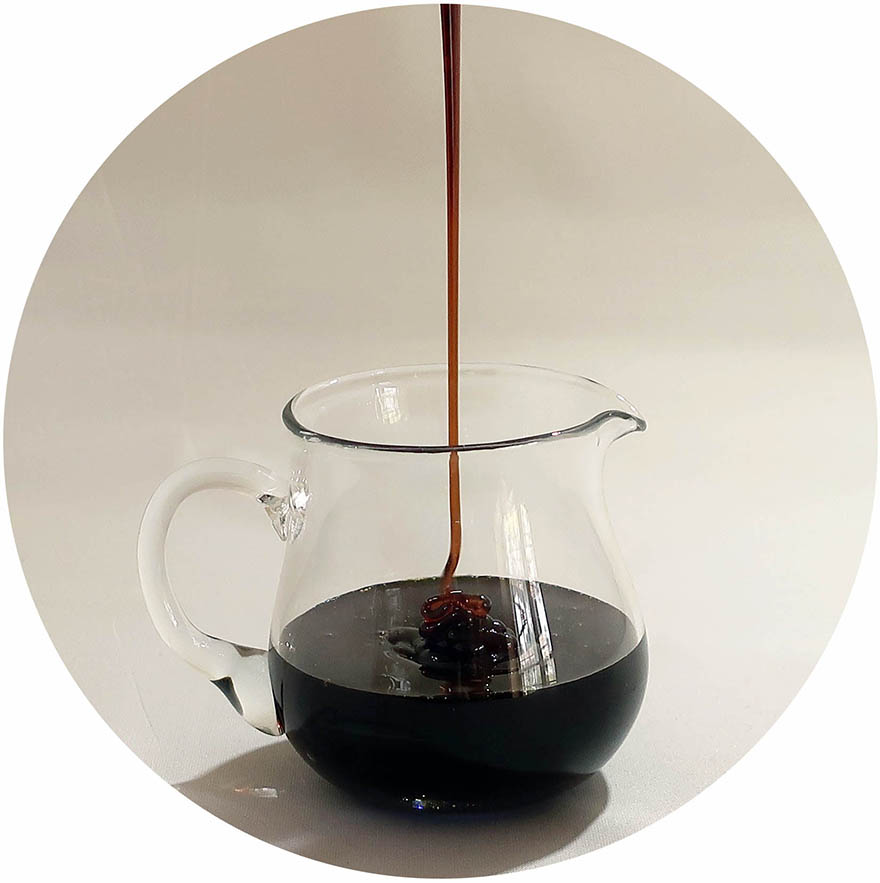 Photo of kuromitsu Okinawan black sugar syrup drizzling into a clear pitcher
