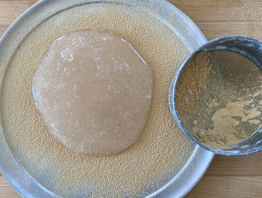 Warabi mochi turned out onto a pan dusted with kinako roasted soybean flour