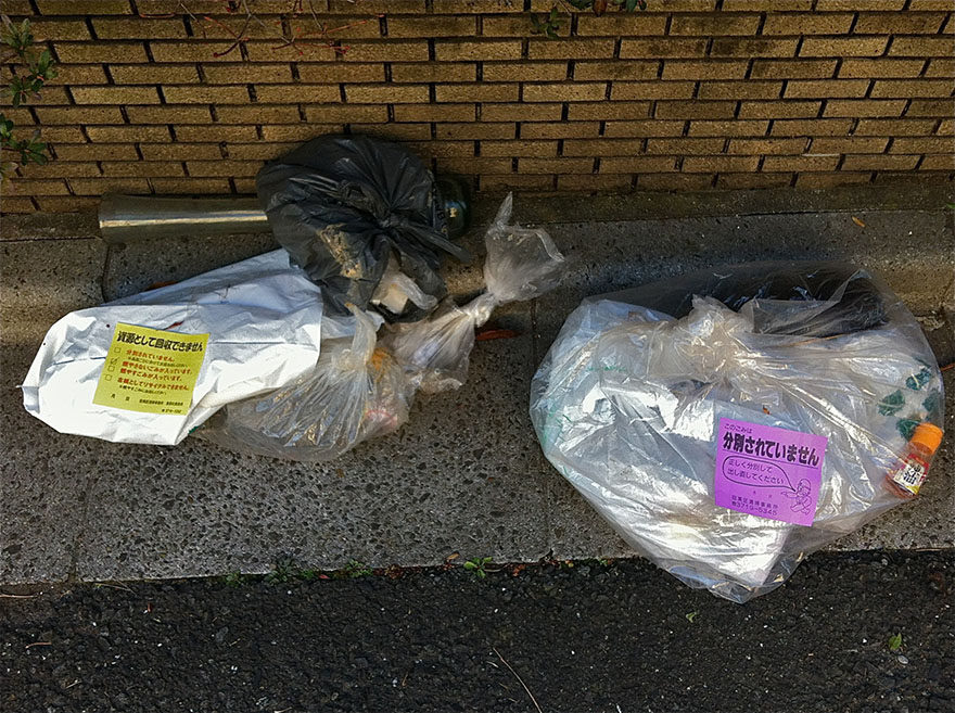 Trash bags rejected by garbagemen in Tokyo because wrong type of bag was used or recycling types were mixed