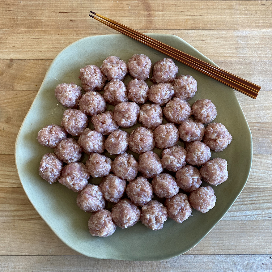Raw chicken meatball tsukune waiting to be cooked