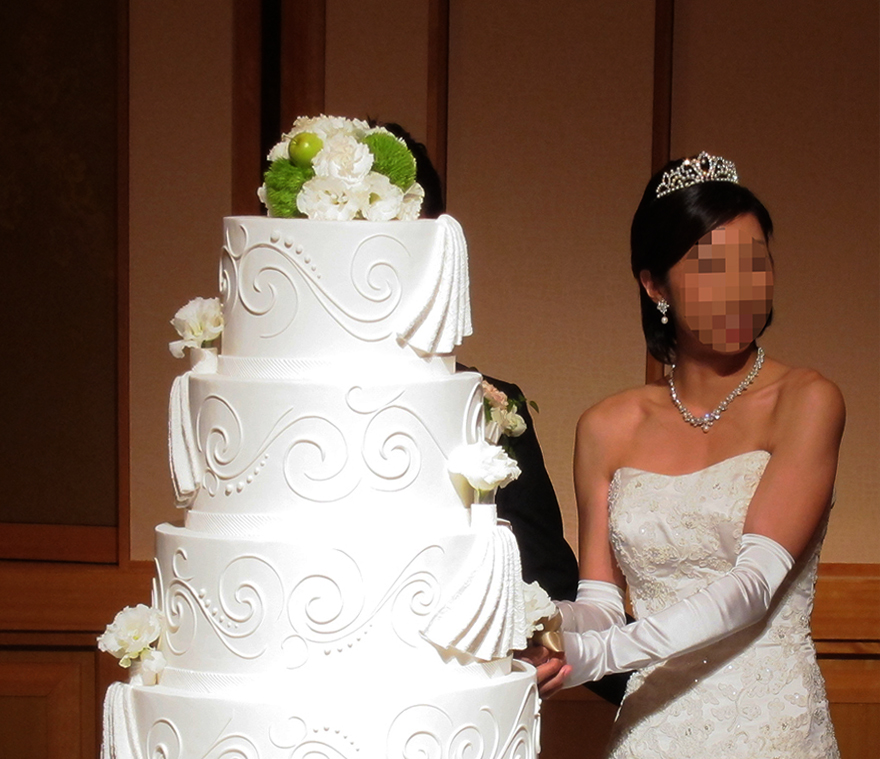 Bride "cutting" a fake cake at a Japanese wedding
