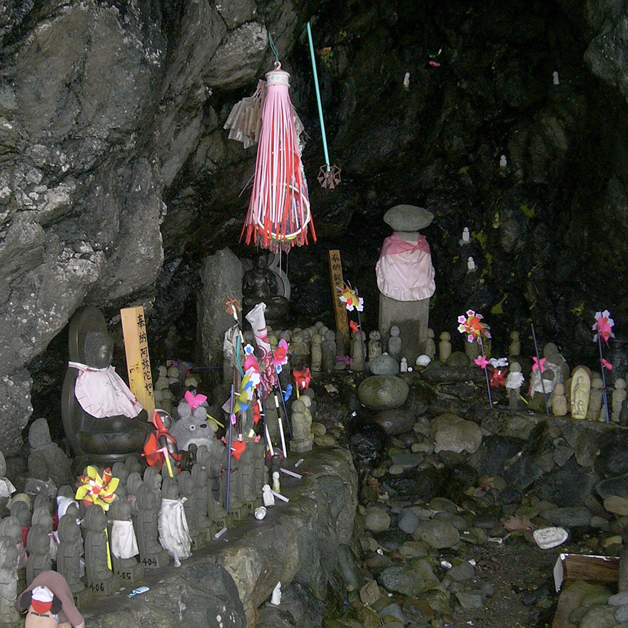Jizo statues offered in a cave memorial for lost children on Sado Island