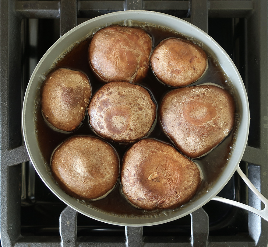 Shiitake mushrooms simmering on stove