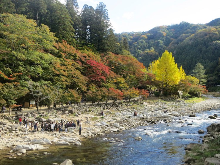 River at Korankei in autumn with tour group assembling for a group photo on the bank