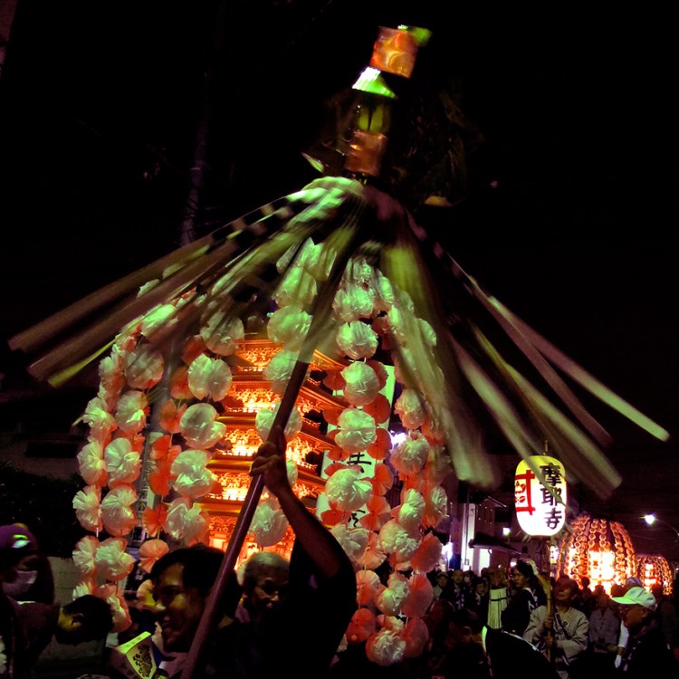 Photo of pagodas parading down the street at night at the oeshiki ikegami festival in Tokyo