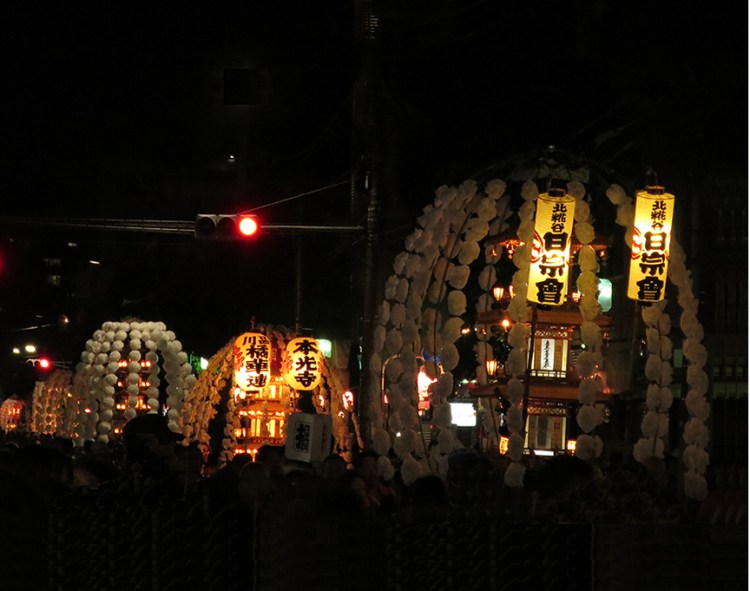 Photo of pagodas parading down the street at night at the oeshiki ikegami festival in Tokyo