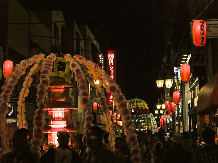 Photo of pagodas parading down the street at night at the oeshiki ikegami festival in Tokyo