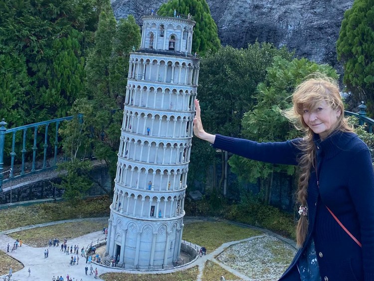 Author Jonelle Patrick holding up the leaning tower of Pisa at Tobu World Square in Nikko