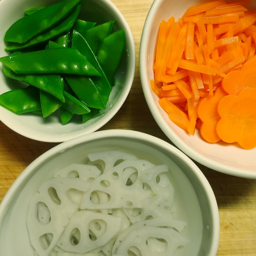 Snow peas, carrots and lotus root, sliced and prepared to put in vegetable salad
